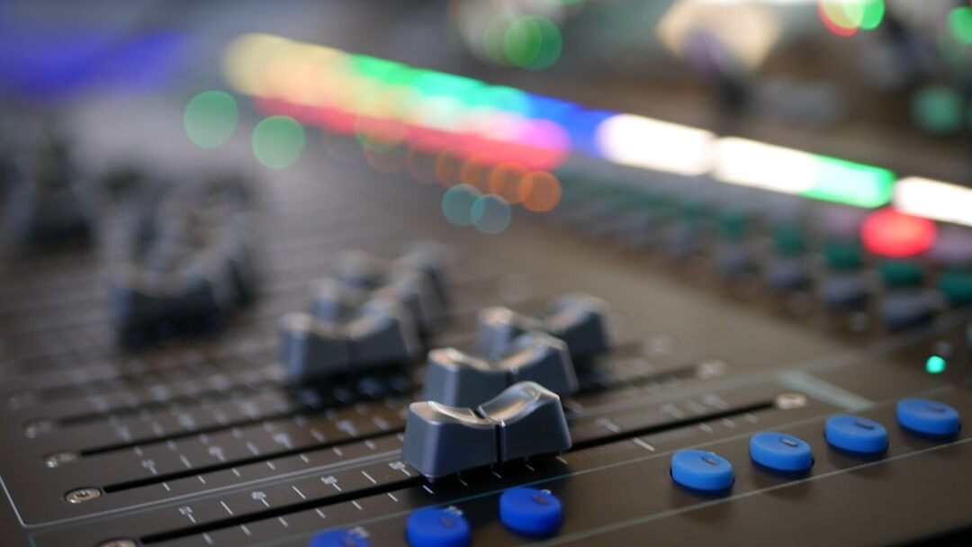 Audio mixing console with sliders and meters
